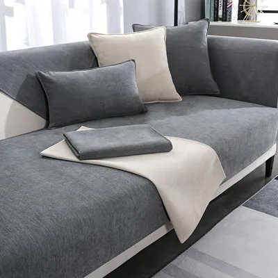 A sectional sofa with multiple cushions and throws, styled in a modern living room setting.