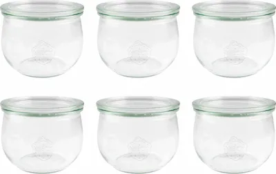 Six clear glass jars with green lids are arranged in two rows of three.