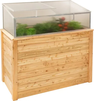 A wooden raised garden bed with a clear lid, containing plants and tomatoes.