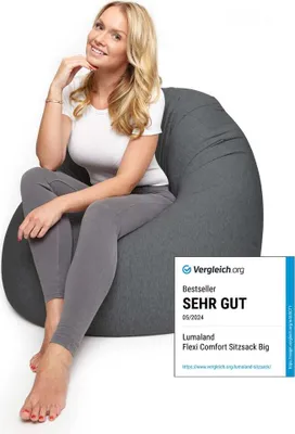 A woman is sitting on a large beanbag chair.