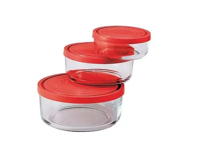A set of three glass food storage containers with red lids, stacked diagonally.
