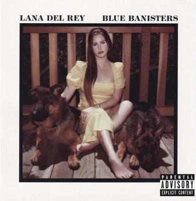 Lana Del Rey sitting on a wooden bench with two German Shepherd dogs.