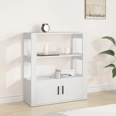 A white sideboard with two doors and two shelves, placed against a light-colored wall with a painting on it.
