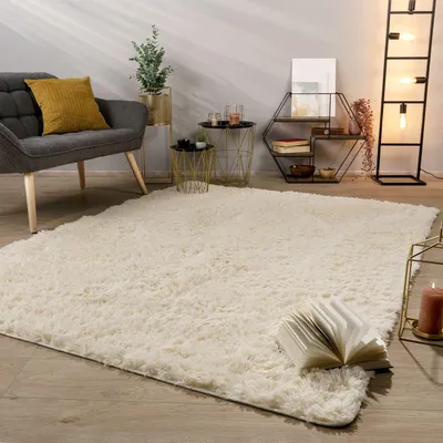 A living room scene with a rug, chair, side tables, and a floor lamp.