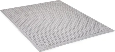 A gray litter mat with a grid pattern of holes, shown from a slightly elevated angle.