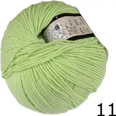 A ball of light green yarn with a label showing product information.