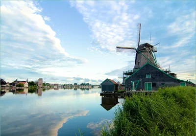 Produktbild von Wallario Fototapete Vliestapete, seidenmatte Oberfläche, einfache Verarbeitung, Größe 200 x 140 cm, Motiv Alte Windmühle an einem Fluss