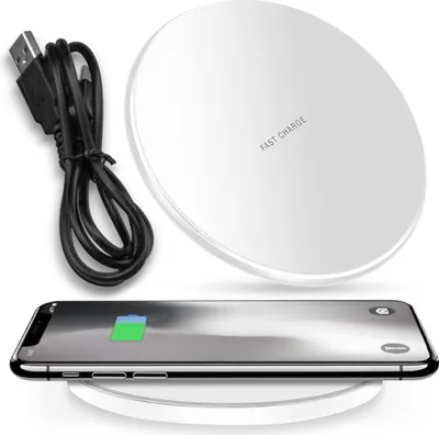 A white wireless charging pad with a black USB cable and a smartphone placed on it, showing a charging battery icon.