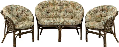 A set of rattan furniture including a loveseat and two armchairs, all with floral patterned cushions, displayed against a white background.