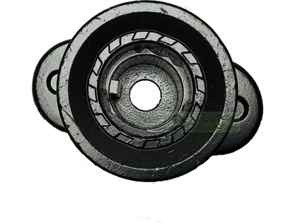 A close-up, overhead view of a metal part, possibly a pulley or bearing, with a central hole and layered components.