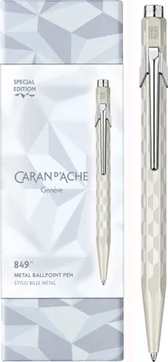 A white Caran d'Ache 849 ballpoint pen and its packaging are displayed against a white background.