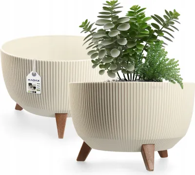 Two cream-colored plant pots with wooden legs are shown against a white background. One pot contains a green plant.