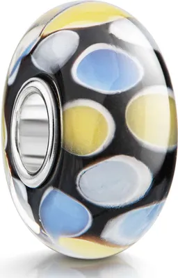 Schwarzer Glas Bead mit gelben, blauen und weißen Punkten, mit schmaler silberner Hülse, leicht schräg fotografiert auf weißem Hintergrund.