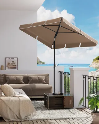 A patio scene with a sofa, umbrella, and a view of the ocean.