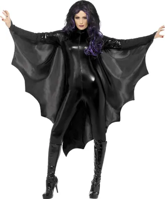 A woman wearing a black bat costume with large wings, standing and posing.