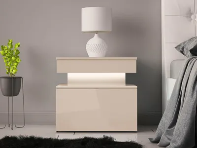 A modern bedroom setting with a nightstand, lamp, and plant.