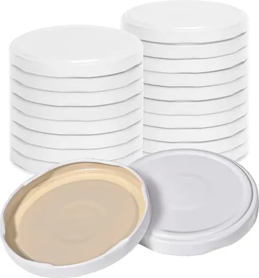 Stacks of white screw-on lids for jars, with one lid shown open to reveal its tan interior.