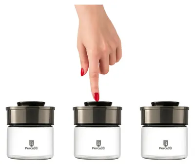 A hand is pressing the lid of one of three identical glass storage jars.