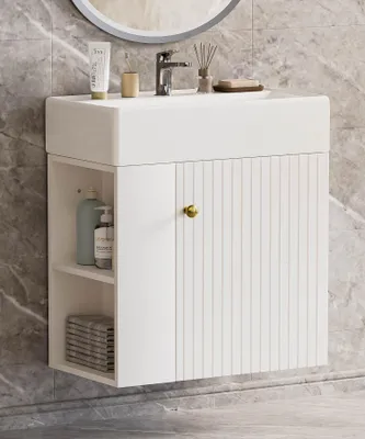 A white bathroom vanity with a sink and faucet, mounted on a marble-tiled wall.