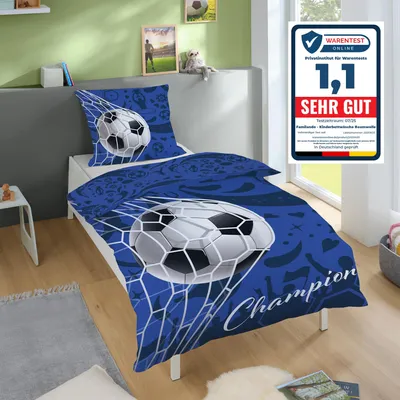 A child's bed with football-themed bedding is shown in a room.