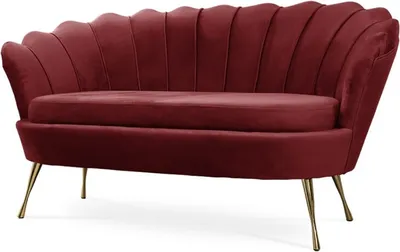 A studio shot of a red velvet sofa with gold metal legs.