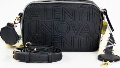 A black Valentino camera bag with an embossed logo and an ecru strap is displayed on a white background.