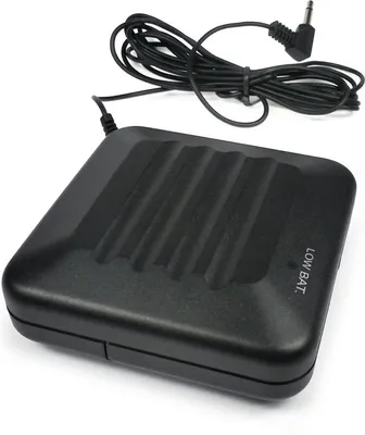 A black electronic device with a coiled cord and a plug is shown on a white background.