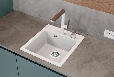 A white kitchen sink with a modern faucet on a gray countertop.