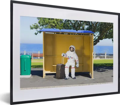 Produktbild von MuchoWow® MuchoWow® Gerahmtes Poster Komischer Astronaut in einem Buswartehäuschen 40x30 cm - Poster mit zchwarzem Bilderrahmen - Bilderrahmen - Poster im Rahmen