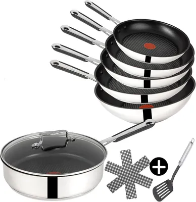 A set of Tefal Jamie Oliver frying pans and a wok, stacked and arranged on a white background, with a single frying pan with a lid in the foreground, and accessories.