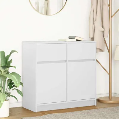 A white sideboard with two drawers is shown in a room with a plant and a coat rack.