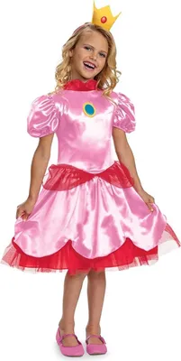 A young girl wearing a Princess Peach costume, including a pink dress, a yellow crown, and pink shoes. She is standing against a white background.