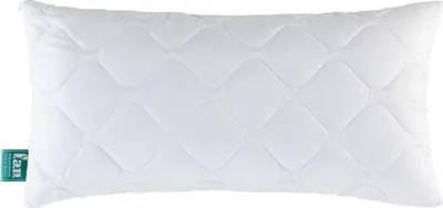 A white quilted pillow with a green tag on the left side.
