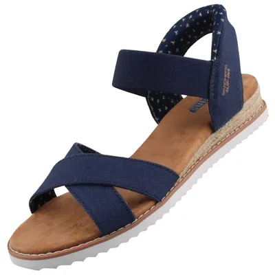 Das Bild zeigt eine blaue Sandale mit einem offenen Design. Die Sandale ist von der Seite zu sehen und hebt die Riemen sowie die Sohle hervor.