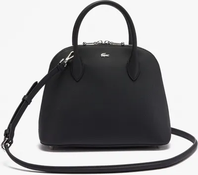 A black Lacoste handbag with a shoulder strap is shown against a white background.