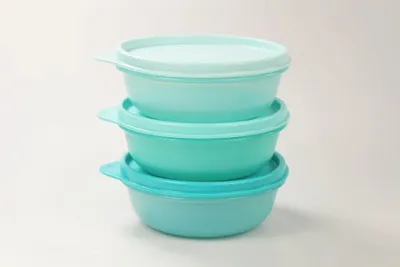 A stack of three Tupperware containers in varying shades of turquoise.