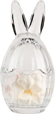 A clear, professional studio shot of a transparent glass Easter egg-shaped candy dish with bunny ears, filled with white candies.