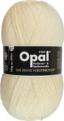 A ball of cream-colored yarn with a black label wrapped around it.