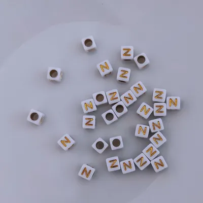 Immagine prodotto di Perline di lettere, 30 pezzi, 6x6 mm, bianche con oro, quadrate, lettera N
