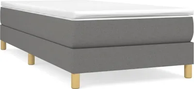 A studio shot of a box spring bed frame with a mattress on top, set against a white background.