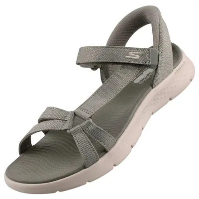 Auf dem Bild ist eine hellgrüne Sandale zu sehen die von der Seite abgebildet ist. Die Sandale hat ein minimalistisches Design mit einem breiten Riemen und einer flachen Sohle.