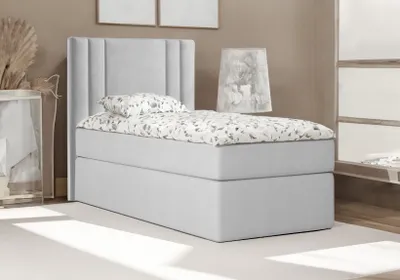 A bedroom scene with a bed and a lamp.