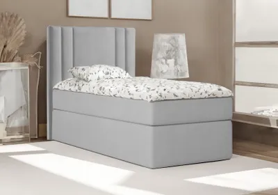 A single bed with a headboard and bedding is shown in a room.