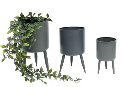Three gray metal planters of different sizes, each with three legs, are displayed against a white background. The largest planter on the left contains a trailing green plant.