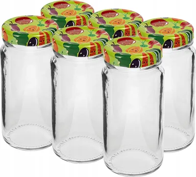 A group of six clear glass jars with decorative lids featuring a vegetable pattern.