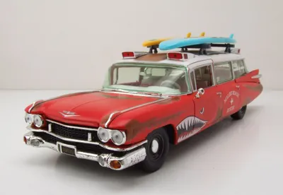 Produktbild von Auto World AW312 Cadillac Eldorado Ambulance Surf Shark 1959 rostig rot mit Surfbrettern 1:18