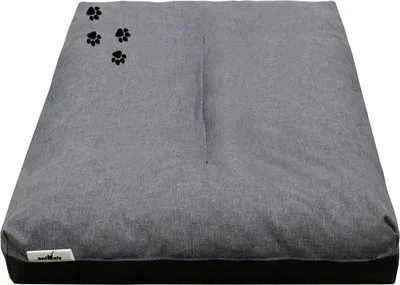 A gray dog bed with black paw print accents.