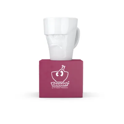 A white mug with a grumpy face design sits on top of a magenta box with the brand logo.