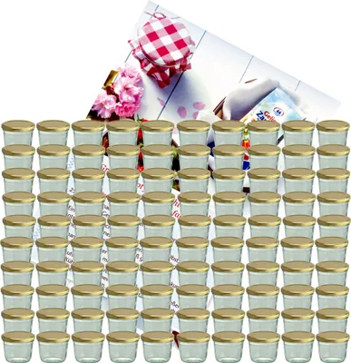A large group of small glass jars with gold lids, arranged in rows, with a decorative element of flowers and a checkered lid in the background.
