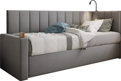 A gray upholstered bed with a tall headboard and bedding.